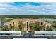Aerial view of condo building with parking and golf course views at 8105 Grand Estuary Trl # 307, Bradenton, FL 34212