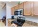 Close-up of kitchen's cooktop and microwave at 8105 Grand Estuary Trl # 307, Bradenton, FL 34212