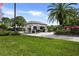 Gated entrance to a community with lush landscaping and palm trees at 8790 Wild Dunes Dr, Sarasota, FL 34241