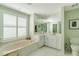 Main bathroom with a corner bathtub, double sink vanity, and a separate shower at 1463 Trune Way, Venice, FL 34292