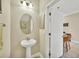 Small powder room with pedestal sink and oval mirror at 204 Crew Ct, Sarasota, FL 34243