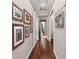 Light and airy hallway with hardwood floors and tasteful wall art at 311 Compass Point Dr # 201, Bradenton, FL 34209