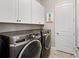 Bright laundry room with washer, dryer, and cabinets at 311 Compass Point Dr # 201, Bradenton, FL 34209