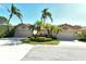 Two-story home with attached two-car garage, lush landscaping, and palm trees at 3416 W Chelmsford Ct # 2, Sarasota, FL 34235