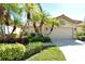 Tan stucco home with tile roof, palm trees, and manicured landscaping at 3416 W Chelmsford Ct # 2, Sarasota, FL 34235