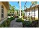 Pathway to entry with wrought iron gate and lush landscaping at 3416 W Chelmsford Ct # 2, Sarasota, FL 34235