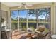 Peaceful sunroom with wicker furniture and scenic golf course views at 3416 W Chelmsford Ct # 2, Sarasota, FL 34235