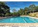 Inviting community pool surrounded by trees at 3416 W Chelmsford Ct # 2, Sarasota, FL 34235