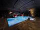 Luminous inground pool with spa at night, under a covered patio at 348 165Th Ne Ct, Bradenton, FL 34212