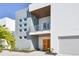Contemporary home with orange door, gray and white exterior, and balcony at 3939 Higel Ave, Sarasota, FL 34242