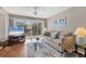 Living room with hardwood floors, sliding doors leading to balcony, and TV at 4110 Ironwood Cir # 301, Bradenton, FL 34209