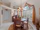 Round dining table with four chairs, in a well-lit room with large windows at 4472 Via Del Villetti Dr, Venice, FL 34293
