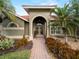 Welcoming entryway with arched doorway and landscaping at 4472 Via Del Villetti Dr, Venice, FL 34293