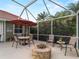 Relaxing screened patio with fire pit, dining area, and seating at 4472 Via Del Villetti Dr, Venice, FL 34293