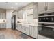 Modern kitchen with white cabinets, a farmhouse sink, and double ovens at 4534 Trento Pl, Bradenton, FL 34211