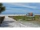 Scenic beach access path with Siesta Key signage, leading to the beautiful white sand beach at 5402 Shadow Lawn Dr, Sarasota, FL 34242