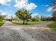 Gravel driveway leading to a charming property with mature trees at 5645 Churchill Downs Rd, Sarasota, FL 34241