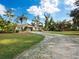 Ranch-style home with a large grassy yard and gravel driveway at 5645 Churchill Downs Rd, Sarasota, FL 34241