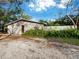 Ranch-style home with a wooden door and landscaping at 5645 Churchill Downs Rd, Sarasota, FL 34241