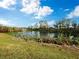 Serene lakefront view with lush greenery and a water fountain at 5645 Churchill Downs Rd, Sarasota, FL 34241