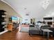 L-shaped living room with hardwood floors, large TV and access to deck at 5645 Churchill Downs Rd, Sarasota, FL 34241