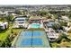 Aerial view showcasing tennis courts, swimming pool, and clubhouse in a community setting at 618 Bird Bay S Dr # 201, Venice, FL 34285