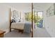 Bright bedroom with a post bed, large window, and view of nature at 618 Bird Bay S Dr # 201, Venice, FL 34285
