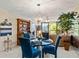 Dining area with glass table, blue chairs, and view to living room at 618 Bird Bay S Dr # 201, Venice, FL 34285