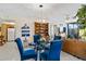 Bright dining area with glass table and blue chairs, adjacent to living room at 618 Bird Bay S Dr # 201, Venice, FL 34285