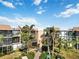 Two-story condo building with lush landscaping and a walkway at 618 Bird Bay S Dr # 201, Venice, FL 34285