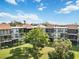 Condo building with a large tree and grassy area at 618 Bird Bay S Dr # 201, Venice, FL 34285