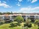 Condo building with a large tree and grassy area at 618 Bird Bay S Dr # 201, Venice, FL 34285