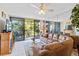 Spacious living room with leather couch and view to balcony and golf course at 618 Bird Bay S Dr # 201, Venice, FL 34285