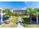 Condo building with palm trees, walkway, and parking at 6505 Stone River Rd # 202, Bradenton, FL 34203