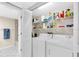 Convenient laundry room with washer, dryer, and storage shelves at 6505 Stone River Rd # 202, Bradenton, FL 34203
