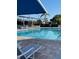 Inviting community pool with lounge chairs and shade umbrellas at 6505 Stone River Rd # 202, Bradenton, FL 34203