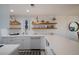 Modern white kitchen with open shelving and a stylish backsplash at 6925 Gulf Of Mexico Dr # 24, Longboat Key, FL 34228