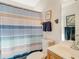 Bathroom with striped shower curtain and wood vanity at 709 Barcelona Ave # D & E, Venice, FL 34285