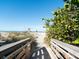Wooden bridge pathway to beach with vegetation at 709 Barcelona Ave # D & E, Venice, FL 34285