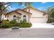 Tan two-story house with a tile roof, two-car garage, and lush landscaping at 7379 Villa D Este Dr, Sarasota, FL 34238