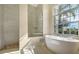 Luxurious bathroom with soaking tub, walk-in shower, and large window at 770 Egret Walk Ln, Venice, FL 34292