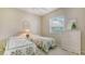 Bedroom with twin beds, white dresser, and window at 770 Egret Walk Ln, Venice, FL 34292