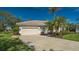 House with palm trees and a three-car garage at 770 Egret Walk Ln, Venice, FL 34292