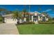 Tan house with lush landscaping and a three-car garage at 770 Egret Walk Ln, Venice, FL 34292