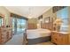 Main bedroom with wood furniture, large windows, and pool view at 770 Egret Walk Ln, Venice, FL 34292