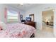 Bright bedroom with floral bedding, dresser, and view at 8105 Grand Estuary Trl # 403, Bradenton, FL 34212