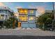 Two-story home with double garage, illuminated at dusk at 106 9Th S St, Bradenton Beach, FL 34217