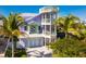 Three-story home with a rooftop deck and tropical landscaping at 112 Mangrove Ave, Anna Maria, FL 34216