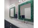 Double vanity bathroom with teal framed mirrors at 112 Mangrove Ave, Anna Maria, FL 34216