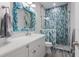 Elegant bathroom with marble vanity, blue tile shower, and unique mirror at 112 Mangrove Ave, Anna Maria, FL 34216